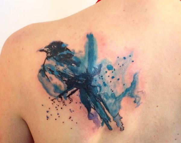 Tatuagem de pega aquarela na escápula 