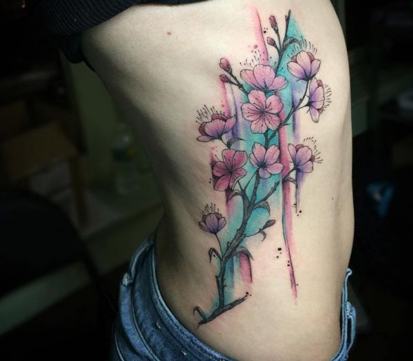 Tatuagem de flor de cerejeira em aquarela nas costelas 