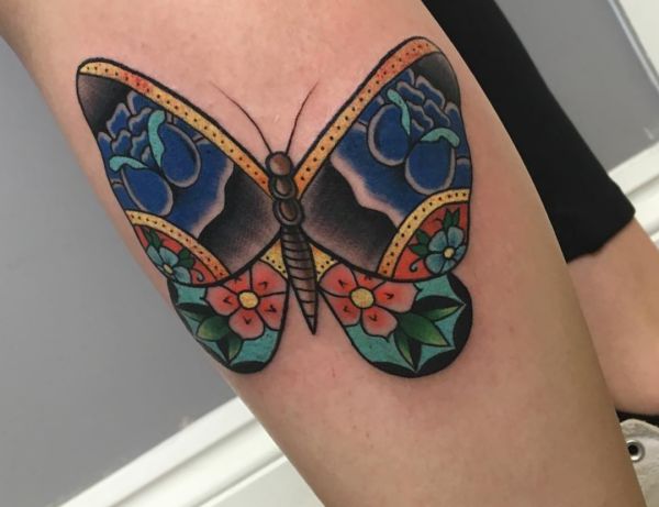 Borboleta com tatuagem de flores na parte inferior da perna 