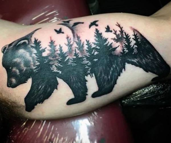 Desenho abstrato urso com floresta no braço 