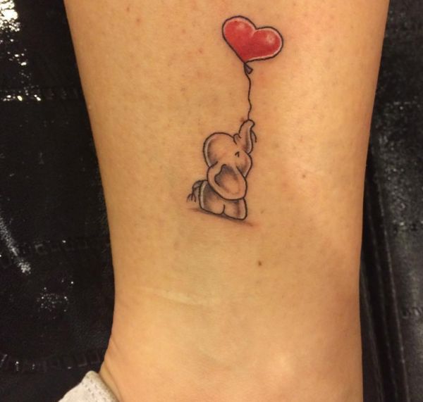 Pequeno elefante fofo com tatuagem de balão de coração na perna 