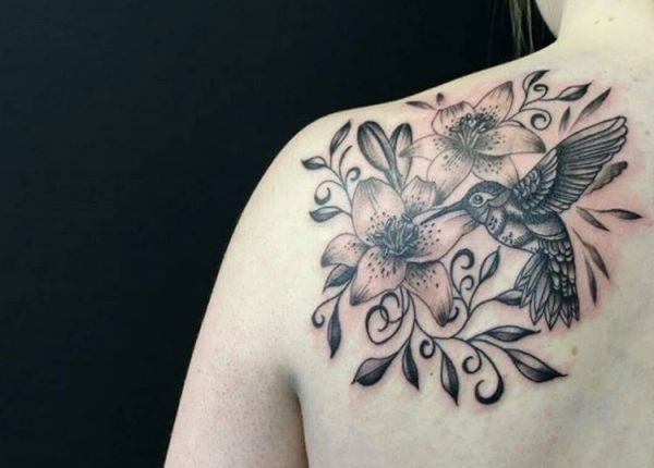 beija-flor com tatuagem de lírio preto branco na escápula 