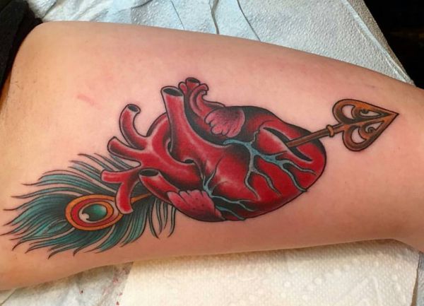 Coração e flecha com tatuagem de pena 