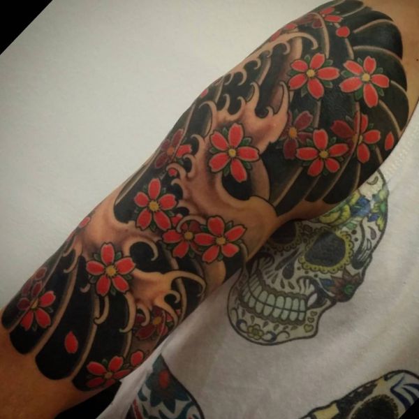 Ondas e tatuagem de flor de cerejeira no braço 