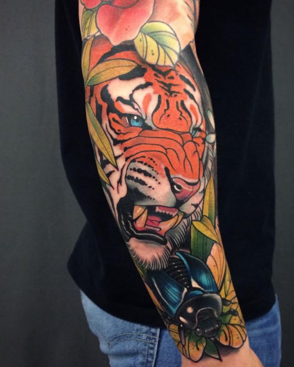 Tigre com tatuagem de besouro no braço 