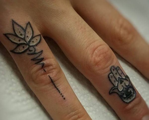 Flor de lótus e hamsa mão tatuagem desenho no dedo 