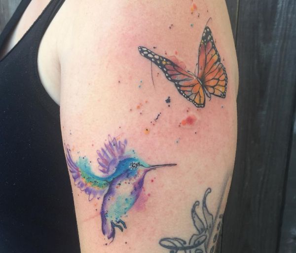 Tatuagem de beija-flor e borboleta no braço 