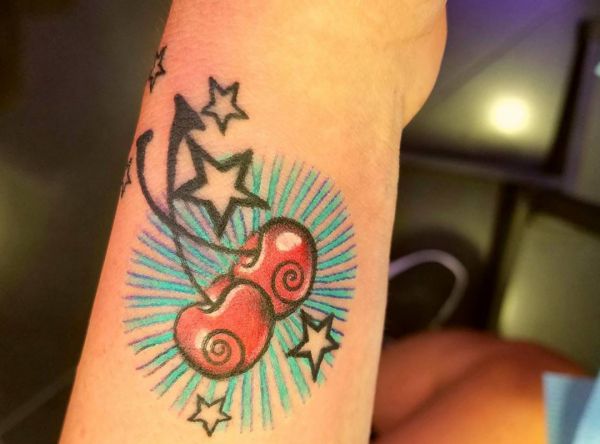 Cereja com estrelas Desenho de tatuagem no pulso 
