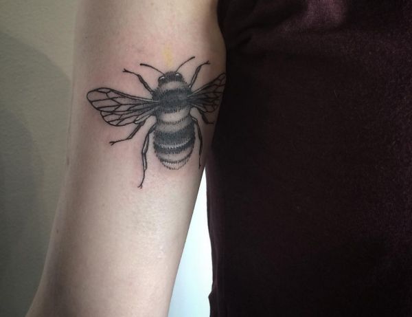 Tatuagem de abelha no braço preto 