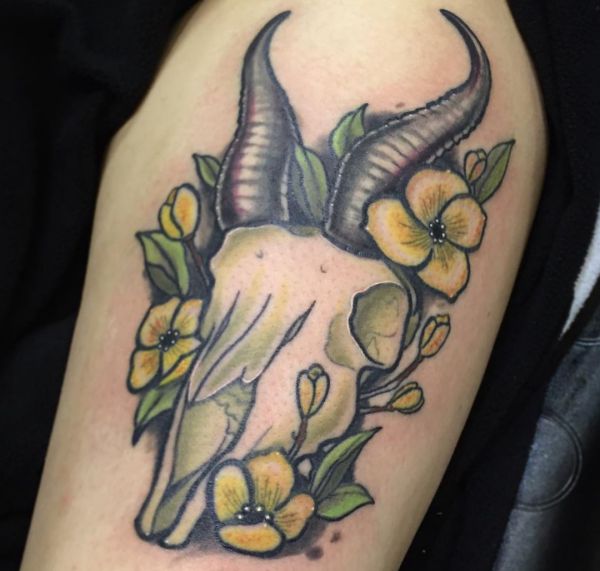 Caveira de tatuagem Gazelle com flores no braço 
