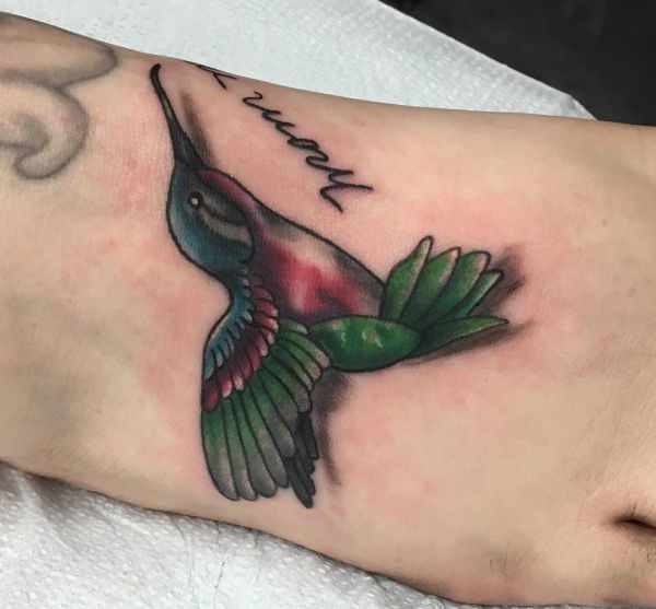 Tatuagem de beija-flor com nome no pé 