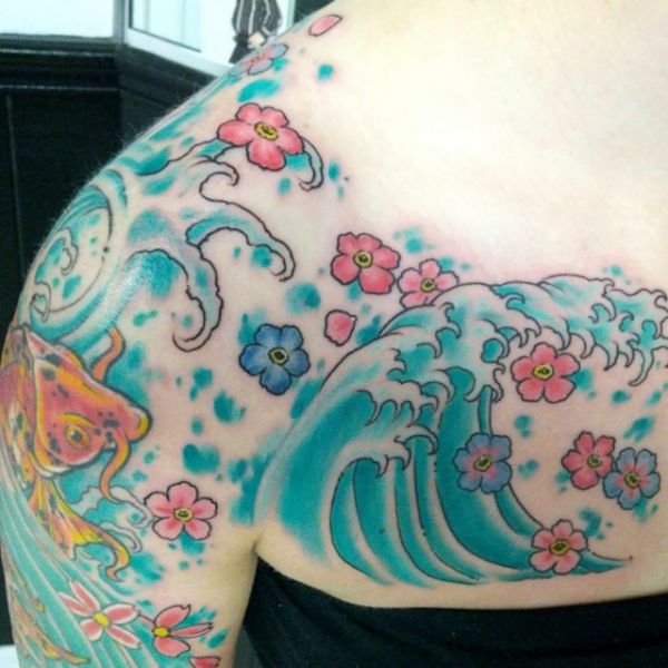Tatuagem de ondas japonesas com flores na clavícula 