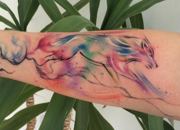 Tatuagem de lobo em aquarela no braço 