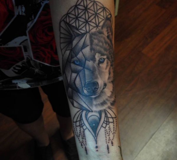 Tatuagem geométrica de cabeça de lobo no braço 