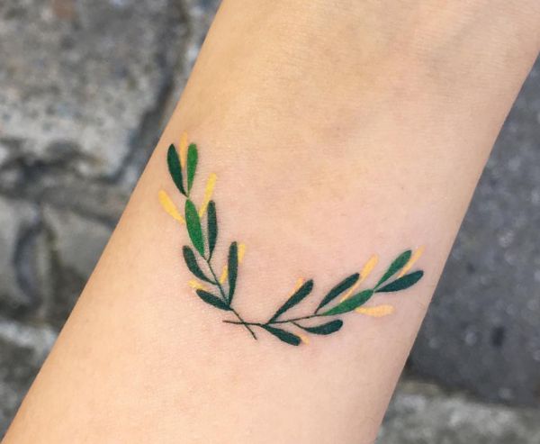 Tatuagem de folhas pequenas no antebraço 