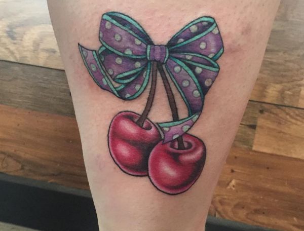 Tatuagem de cereja com laço na perna 