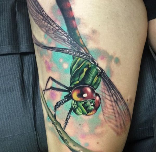 Tatuagem realista de libélula na coxa 