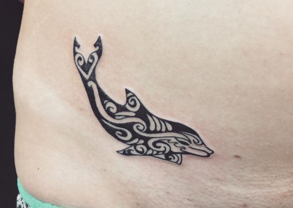 Tatuagem de golfinho tribal na barriga para mulher 