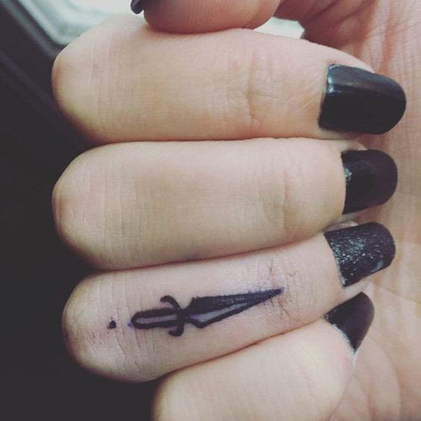Design de tatuagem de espada no dedo 