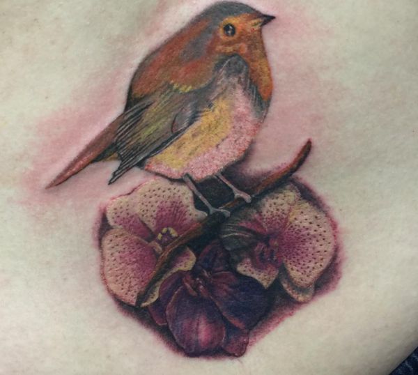 Tatuagem de orquídea com pássaro na parte inferior das costas 